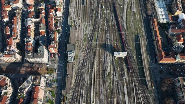 Aerial view of the railroad tracks, a red train is passing in 4k