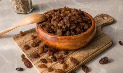 Small wooden plate full of raisins. wooden container with raisins on cutting board