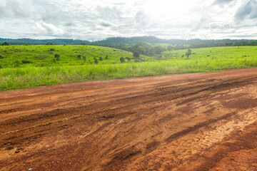 Landscape of gravel road in countryside with meadow. Road in rainy season.