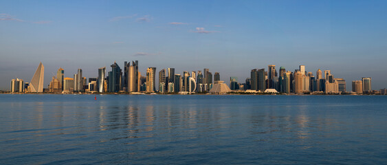 Panorama photo for a view of the Doha Corniche and the towers, one of the most beautiful places in Qatar with blue sky 