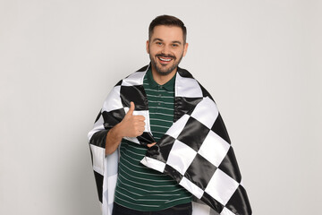 Man with checkered flag showing thumb up on white background