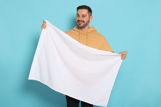 Man with blank white flag on light blue background. Mockup for design
