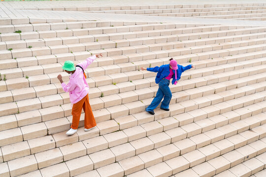 Carefree multiracial couple dancing on staircase