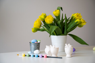 Easter banner with cute bunny shaped egg holders in pastel colors near tulips. Paint eggs.Prepare for holiday