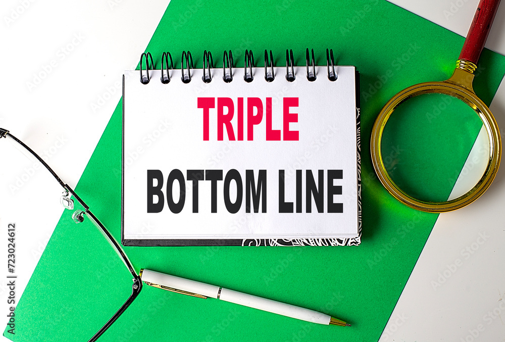 Poster triple bottom line text on notebook on green paper