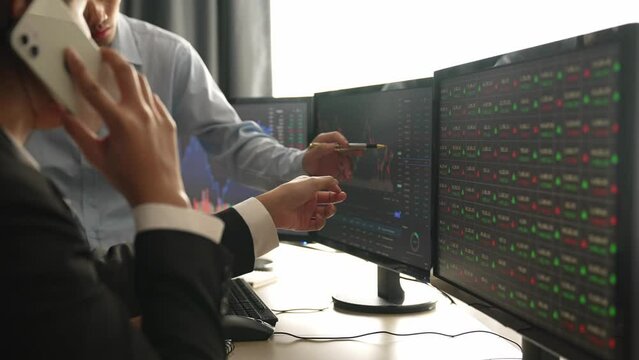 Slow motion business investors in stock trading company analyzing stock exchange marketing looking at monitors analyzing candle bar price for loss and grow up gain and profits. Burgeoning