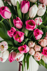 a vase filled with pink and white tulips