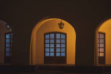 Illuminated Arcades of a medieval building, in the old city center of Sibiu. Warm and cold light. Night view of beautiful estate of Sibiu’s historic center, Romania. Night image of the old house.