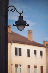 The lamp in vintage style on the background of medieval city in Romania, Europe. Ancient lantern on the wall in old town. 