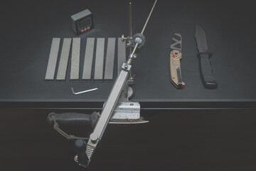 Workshop. Sharpening knives on a machine with diamond stones. - obrazy, fototapety, plakaty
