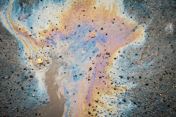 Dirty multi-colored stain from engine oil on asphalt