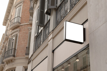 Blank store sign in a classic urban setting, perfect for businesses to superimpose their logo or...