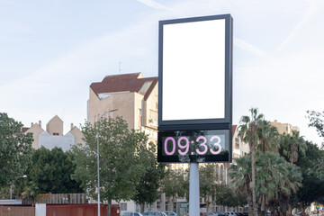 Urban digital clock post with a blank advertising panel against a cityscape, ideal for promotions....