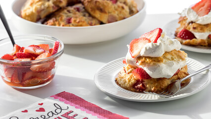 Servings of freshly prepared strawberry shortcakes, against a sunny window.