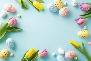 Cheerful Spring Greetings Setup: top view of colorful eggs, and tulips on a pastel blue surface. Perfect for messages or advertisements with available text space - obrazy, fototapety, plakaty