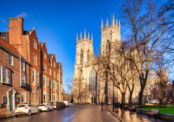 York on a sunny winter day, the west facade of the minster from Duncombe Place, people strolling in...