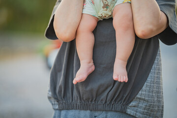 抱き抱えられる赤ちゃんの足