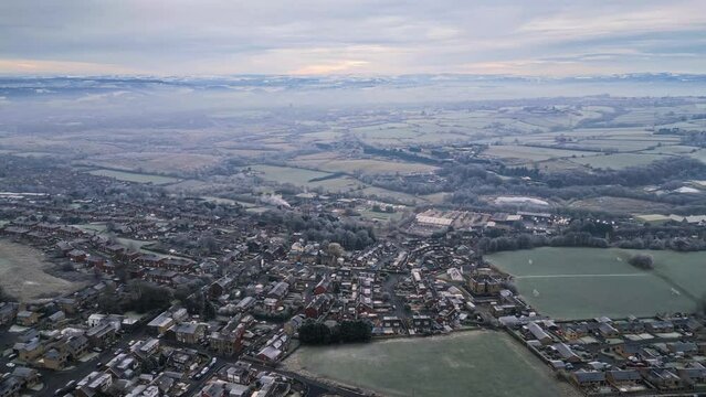 Aerial Drone Video Footage showing a snowy landscape in a suburban UK town.