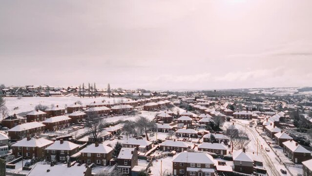 Aerial Drone Video Footage showing a snowy landscape in a suburban UK town.