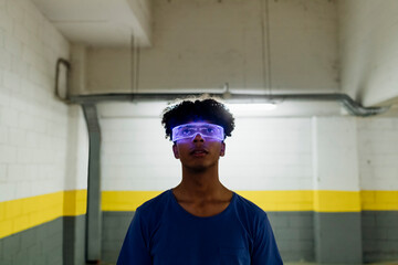 Young man wearing augmented reality glasses in subway