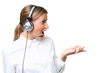 Telemarketer caucasian woman working with a headset over isolated background with surprise facial...