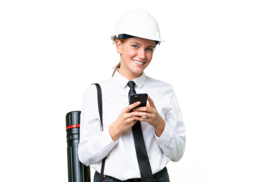Young architect caucasian woman with helmet and holding blueprints over isolated background sending a message with the mobile