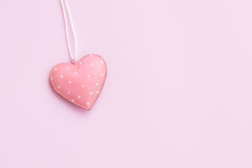 Steel pink heart hanging on a white rope on pink background, Vintage Pink heart shape
