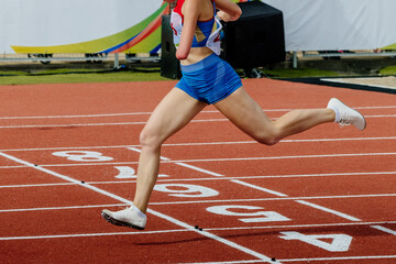 female runner para-athlete on limb deficiency running finish line track stadium, summer para athletics championships