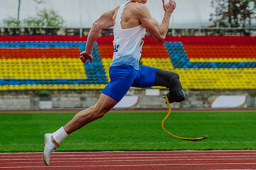 male runner sprinter on prosthesis running stadium track, disabled athlete para athletics...
