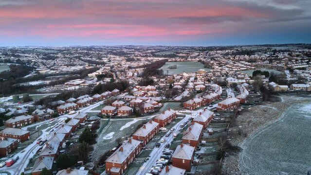 Aerial Drone Video Footage showing a snowy landscape in a suburban UK town.
