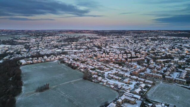 Aerial Drone Video Footage showing a snowy landscape in a suburban UK town.