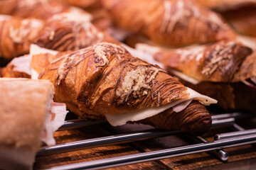 Delicious fresh croissants with cheese and ham slices 