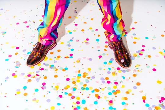 Man standing over confetti on white floor