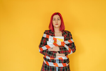 Sad woman tied with tape against yellow background