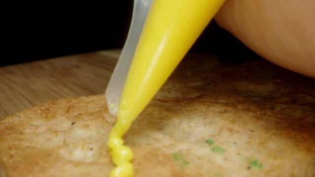 With yellow icing from the pastry bag, they cover gingerbread for decoration. Dolly slider, close up.