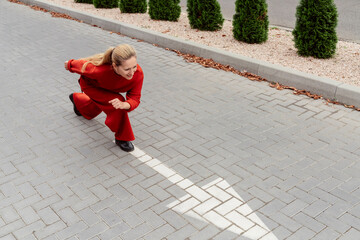 Blond woman with ponytail preparing to run near arrow sign on road