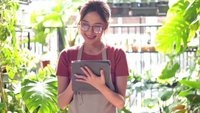 social distancing and work from home. Asian woman small business owner working with digital tablet computer Communicate with customers during online at home. Flower and plant online shop