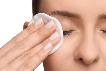 Foto op Canvas Woman removing makeup with cotton pad on white background, closeup © New Africa