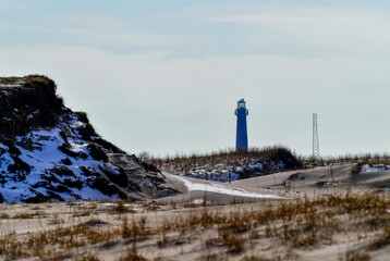 Winter view of Barnegat Lighthouse on the background between sand dunes. Island Beach State Park, Long Beach Island, New Jersey, USA.