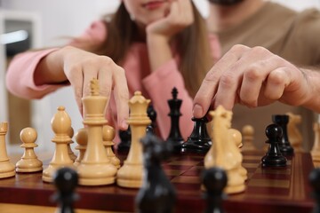 Father teaching his daughter to play chess, closeup