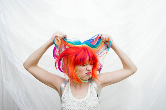 Woman pulling hair in front of plastic backdrop