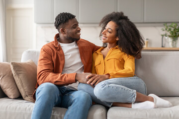 Cheerful millennial black lovers couple enjoying time together at home
