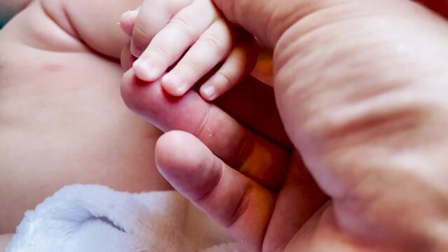 Baby is holding daddy hand. happy family child dream concept. close-up of a hand with a baby. close-up of father hand with baby. Close-up of newborn hand on lifestyle dad
