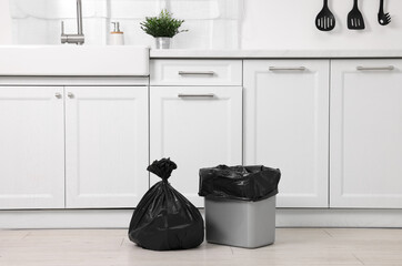 Plastic garbage bag and trash can in kitchen