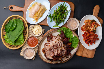 Korean food, bossam, boiled pork, pig feet, steamed pork feet, side dishes, lettuce, garlic bossam, perilla leaves, chives, kimchi