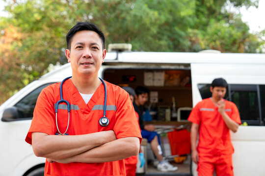 portrait professional asian paramedic proudly standing crossed arms beside ambulance,concept of emergency medical service worker, rescue ambulance at work outside.