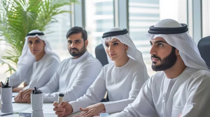 Fotobehang Group of middle-eastern corporate business people wearing traditional emirati clothes meeting in the office in Dubai - Business team working and brainstorming in the UAE © Sasint