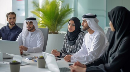 Group of middle-eastern corporate business people wearing traditional emirati clothes meeting in the office in Dubai - Business team working and brainstorming in the UAE - obrazy, fototapety, plakaty