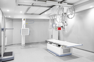 X-ray department in modern hospital. Radiology room with scan machine with empty bed. Scanning chest, heart, lungs in modern clinic office. X-ray machine with control panel and scanning screen.