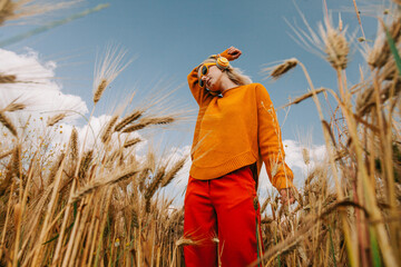 Blond woman listening to music in wheat field